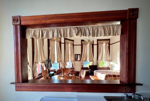 a mirror reflecting a bedroom with a bed at The Monarch Hotel in Port Townsend
