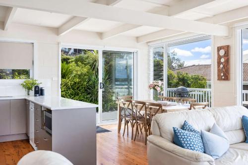 a kitchen and living room with a couch and a table at The Corner Cottage in Mollymook