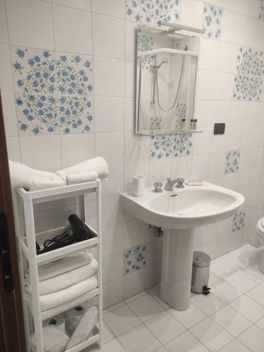 a white bathroom with a sink and a mirror at Una finestra su Savona in Savona