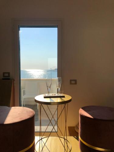 two wine glasses sitting on a table in front of a window at Palese Profumo di Mare in Santo Spirito