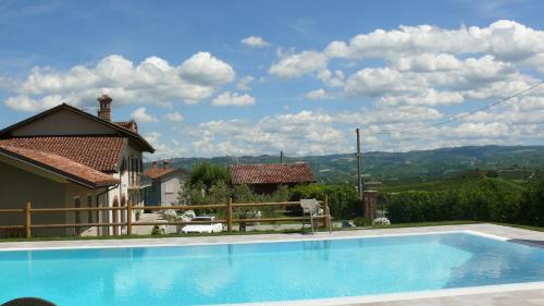 a swimming pool in front of a house at Villa Crissante in La Morra