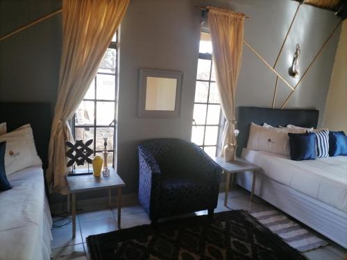 a living room with a bed and a couch and windows at Matlapeng Country Estate in Vanderbijlpark