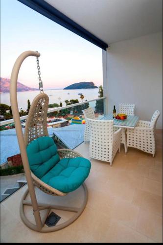 a swing chair in a room with a view of the water at Luxury Apartment Anastasia Tre canne in Budva