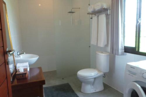 La salle de bains est pourvue de toilettes blanches et d'un lavabo. dans l'établissement Villa Triyuna, our little paradise, à Banjar