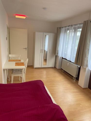 ein Schlafzimmer mit einem Bett und einem Tisch sowie ein Esszimmer in der Unterkunft Zimmer im Herzen von Durlach in Karlsruhe