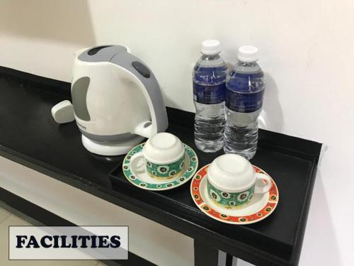 a tea kettle and two bottles of water on a counter at JERANTUT HILL HOTEL in Jerantut