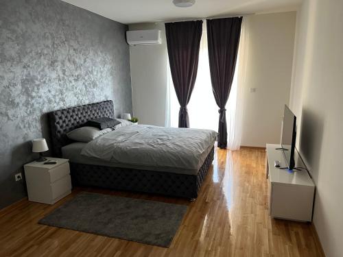 ein Schlafzimmer mit einem Bett und einem TV in der Unterkunft KoTa grey in Karaburma