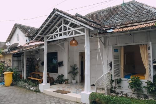 a white house with awning and a patio at Roemah Renjana Yogyakarta in Timuran