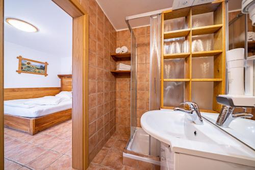a bathroom with a sink and a mirror and a bed at Hiša vina Cuk in Lendava