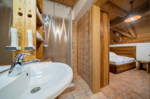 a bathroom with a sink and a bed in a room at Hiša vina Cuk in Lendava