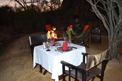 a table with a white table cloth and flowers on it at Thakadu Bush Lodge Naka Sanga in Mabula