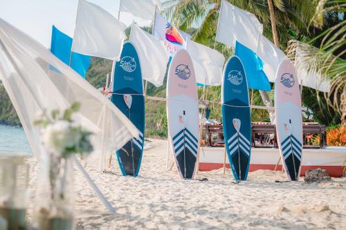 a bunch of surfboards are lined up on a beach at Kerala Coco Resort in Ko Samed