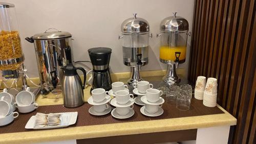 un bancone con tazze e piattini su un tavolo di Al Muhaidb Residence Khorais a Riyad