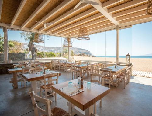 een restaurant met tafels en stoelen en het strand bij Agrari Ninemia Mykonos in Agrari