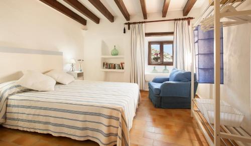 a bedroom with a bed and a blue chair at Ancora 1 in Cala de Sant Vicenc