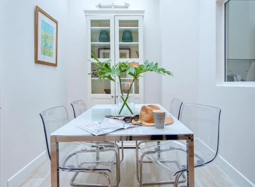 セビリアにあるArenal Apartamento Centro Histórico 4 paxのダイニングルームテーブル(椅子付)、花瓶