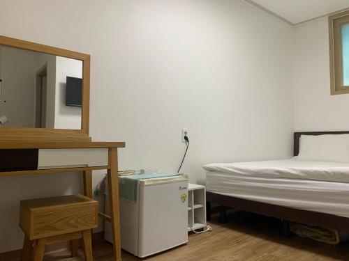um quarto com uma cama e um espelho ao lado de uma cama em Hamory Guesthouse Dongdaemun em Seul
