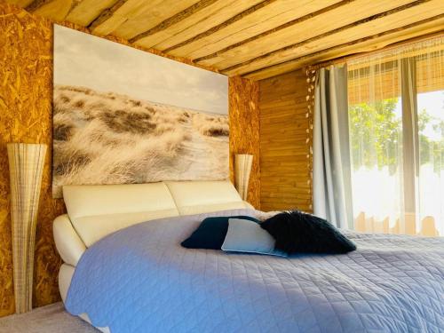 a bedroom with a bed in a wooden room at Sea Side Kaltene in Kaltene
