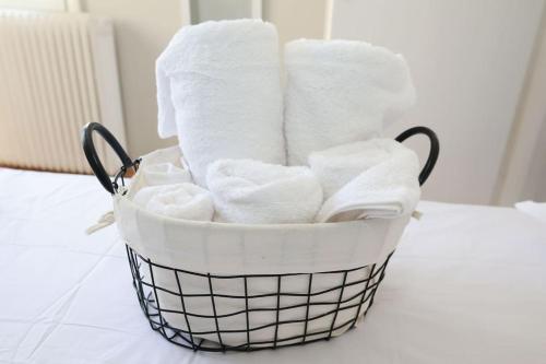 una cesta llena de toallas blancas en un mostrador en Beautiful apartment in Plomari, en Plomari