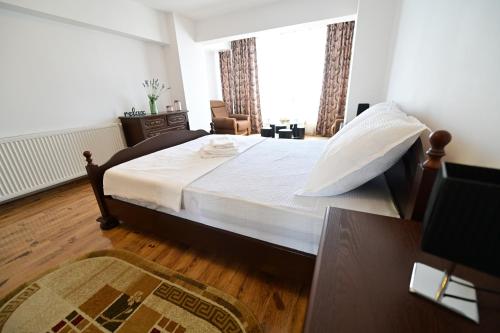 ein Schlafzimmer mit einem großen Bett und einem Fenster in der Unterkunft Vacation Apartment with free parking in Sibiu
