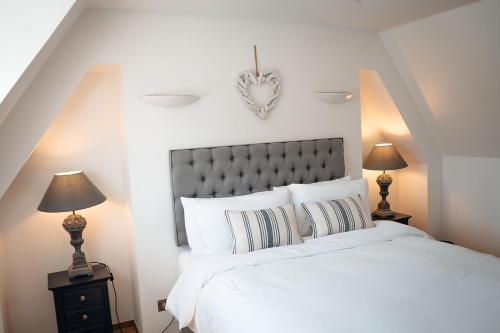 une chambre avec un grand lit blanc avec deux lampes dans l'établissement Unique 2 Bedroom Cottage in Fittie (Footdee), à Aberdeen