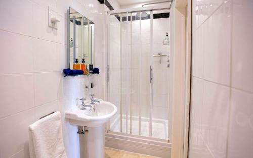 biała łazienka z umywalką i prysznicem w obiekcie The Ship in Dock Inn w mieście Dartmouth
