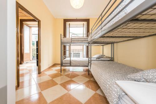 sypialnia z łóżkiem piętrowym i podłogą wyłożoną kafelkami w obiekcie Grand Latina Apartment w Madrycie