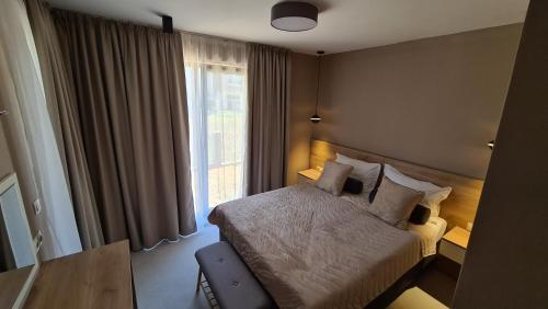 a hotel room with a bed and a window at NEA Apartments in Ahtopol