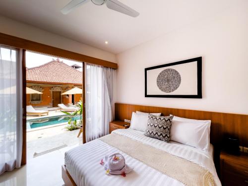 een slaapkamer met een bed en een zwembad bij Puspa Ayu Villas & Apartments in Kuta