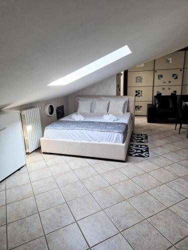 a bedroom with a white bed and a tiled floor at Beinasco Apartment - Le Terrazze Palace in Beinasco