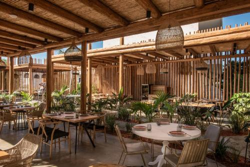 a restaurant with tables and chairs and wooden ceilings at Indigo Inn Casa Adults Only in Hersonissos