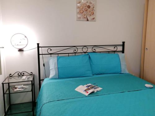 een slaapkamer met een blauw bed met een zwart hoofdeinde bij Symphony House Ravello in Ravello
