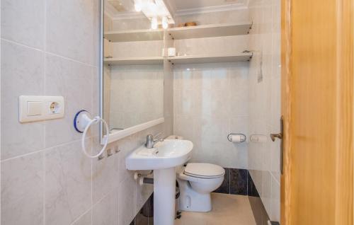 a white bathroom with a toilet and a sink at 2 Bedroom Lovely Home In Santa Pola in Santa Pola