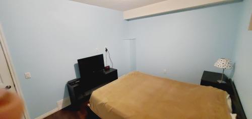 a small bedroom with a bed and a lamp at Studio Fort McMurray in Fort McMurray