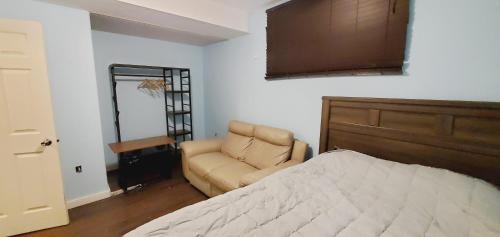 a bedroom with a bed and a chair next to a door at Studio Fort McMurray in Fort McMurray