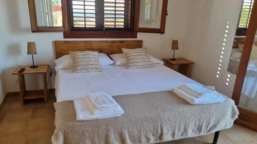 1 dormitorio con 1 cama blanca grande con almohadas en La finestra a tramontana en Favignana