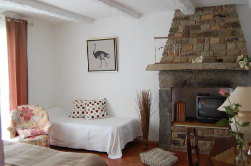 une chambre avec un lit et une cheminée dans l'établissement Les Chambres de Kerzerho, à Erdeven