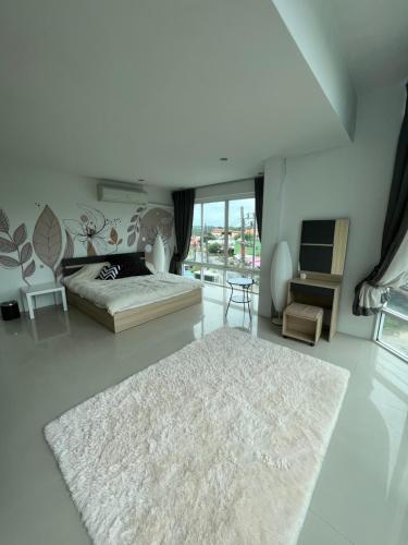 a white bedroom with a bed and a rug at The CHU cafe / guesthouse in Nai Harn Beach