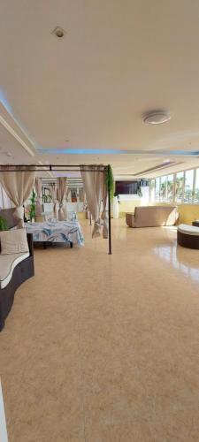 una grande stanza con divani e tavoli in un edificio di First line of the ocean, 3 bedrooms & Free wifi a Playa de las Americas
