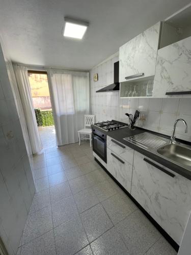 uma cozinha branca com um lavatório e um fogão em Casa-cristy em Palermo