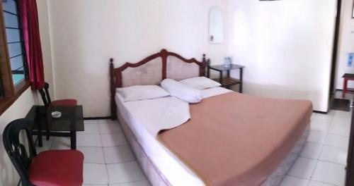 een slaapkamer met een groot bed met 2 kussens bij Liemas hotel in Pasuruan