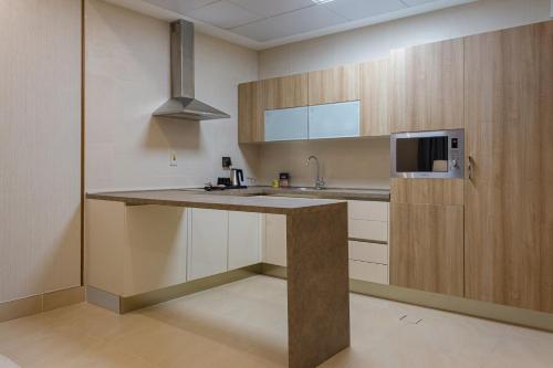 a kitchen with a sink and a microwave at Sarwat Park Hotel Riyadh - Diplomatic Quarter in Riyadh