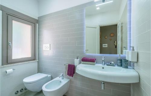 a white bathroom with a sink and a toilet at Nice Home In Orte With Outdoor Swimming Pool, Internet And 2 Bedrooms in Orte