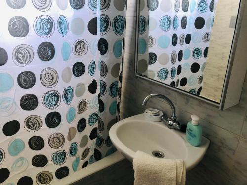 a bathroom with a sink and a shower curtain at Mini Villas Avra in Keratokampos