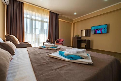 a hotel room with a large bed with towels on it at OneTime Hotel in Anapa