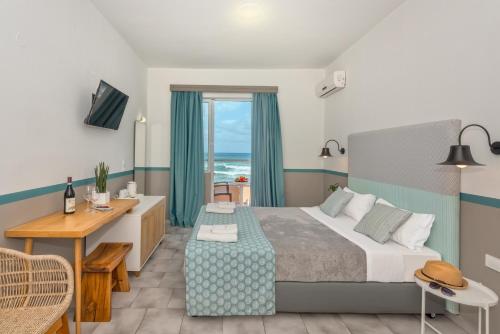 a hotel room with a bed and a desk and a window at Solimar Turquoise - Adults Only in Agia Marina Nea Kydonias