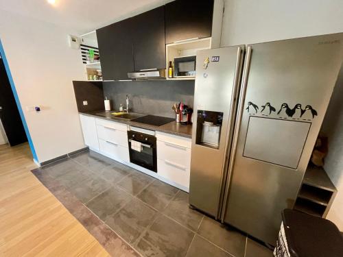 uma cozinha com um grande frigorífico de aço inoxidável em A l’Orée du bois de Vincennes 3 pièces avec balcon em Joinville-le-Pont