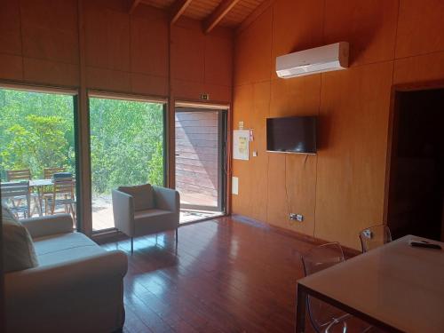 a living room with a couch and a tv at Sobre Aguas Camping in Bragança