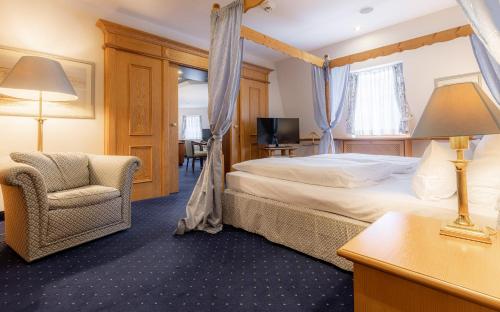 a hotel room with a bed and a chair at Waldhaus Reinbek in Reinbek