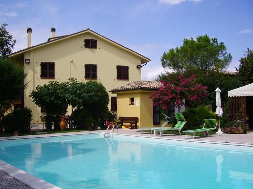 a swimming pool in front of a house at Agriturismo Il Casale in Morrovalle